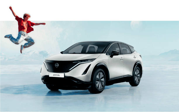 Nissan Ariya branco num cenário de montanha, com uma pessoa a saltar junto ao veículo. 