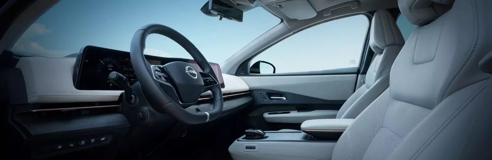 Interior do Nissan Ariya com bancos em pele clara, volante de couro com logótipo Nissan e duplo ecrã digital panorâmico no painel de instrumentos