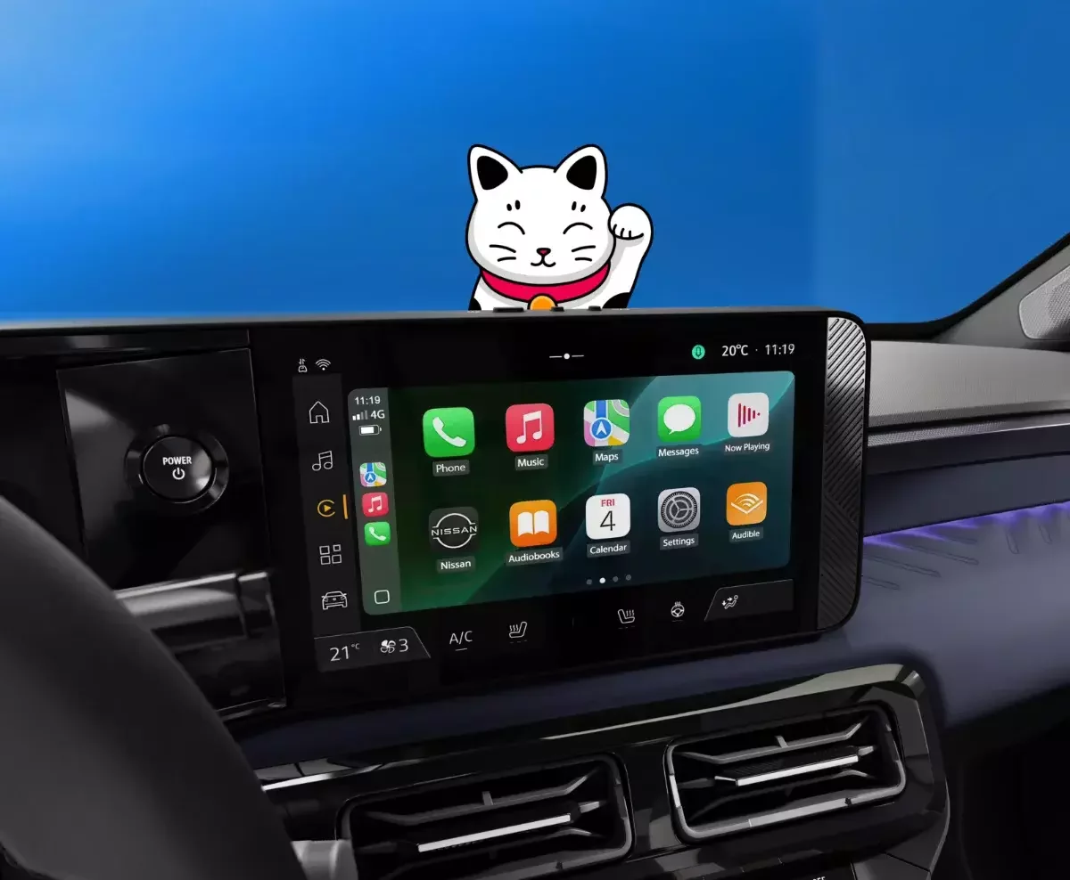 Sistema de infotainment de um Nissan com ecrã digital e aplicações, com ilustração de um gato animado por cima.