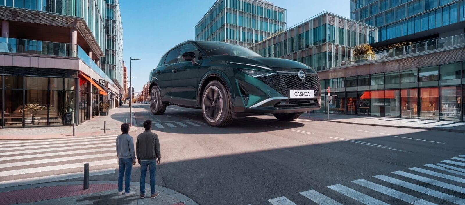 Nissan Qashqai visto de frente, em tamanho grande, no meio da cidade com duas pessoas a observar.