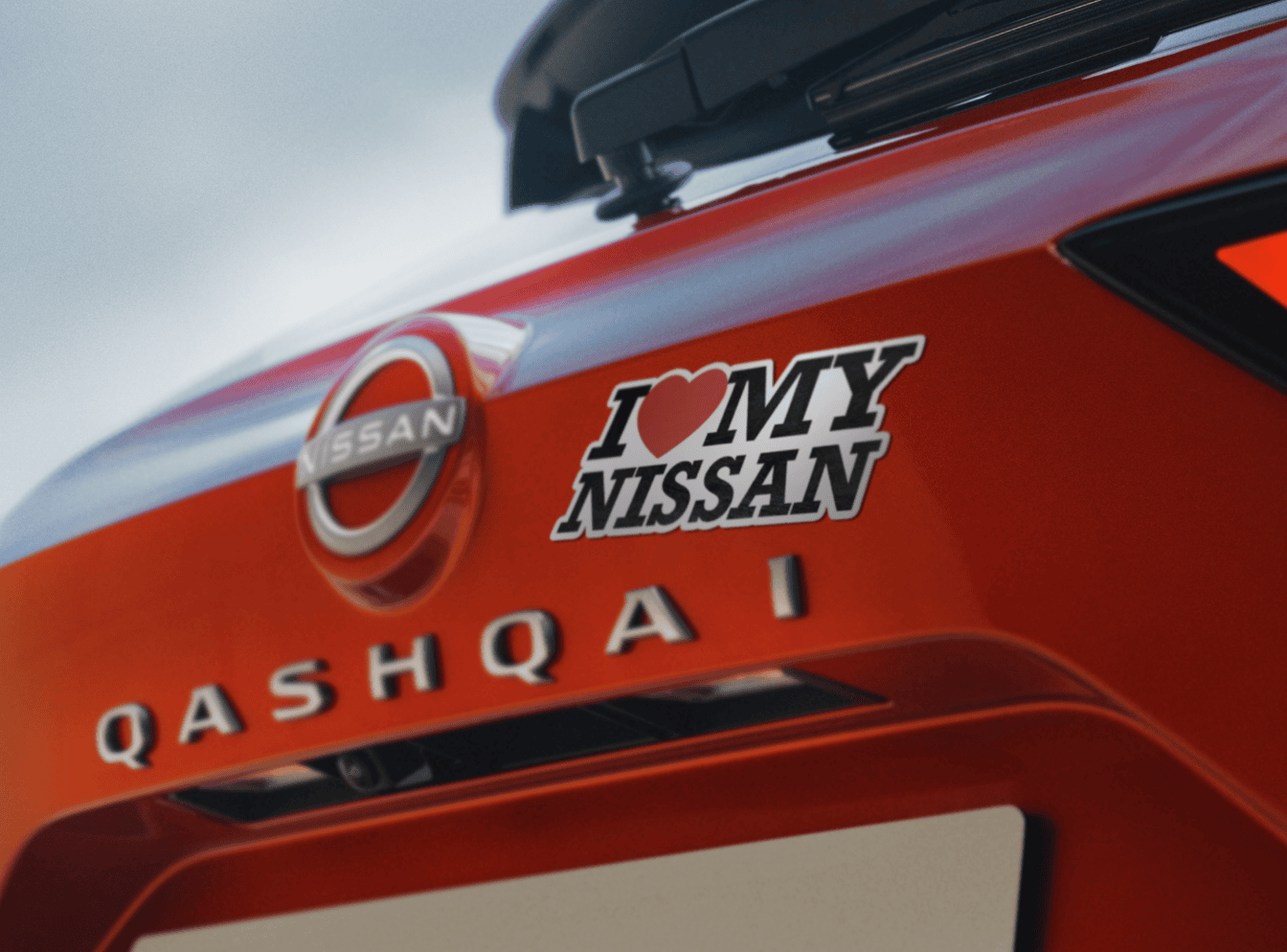Nissan Qashqai em movimento numa avenida urbana, junto a um outdoor da campanha Fan Day.