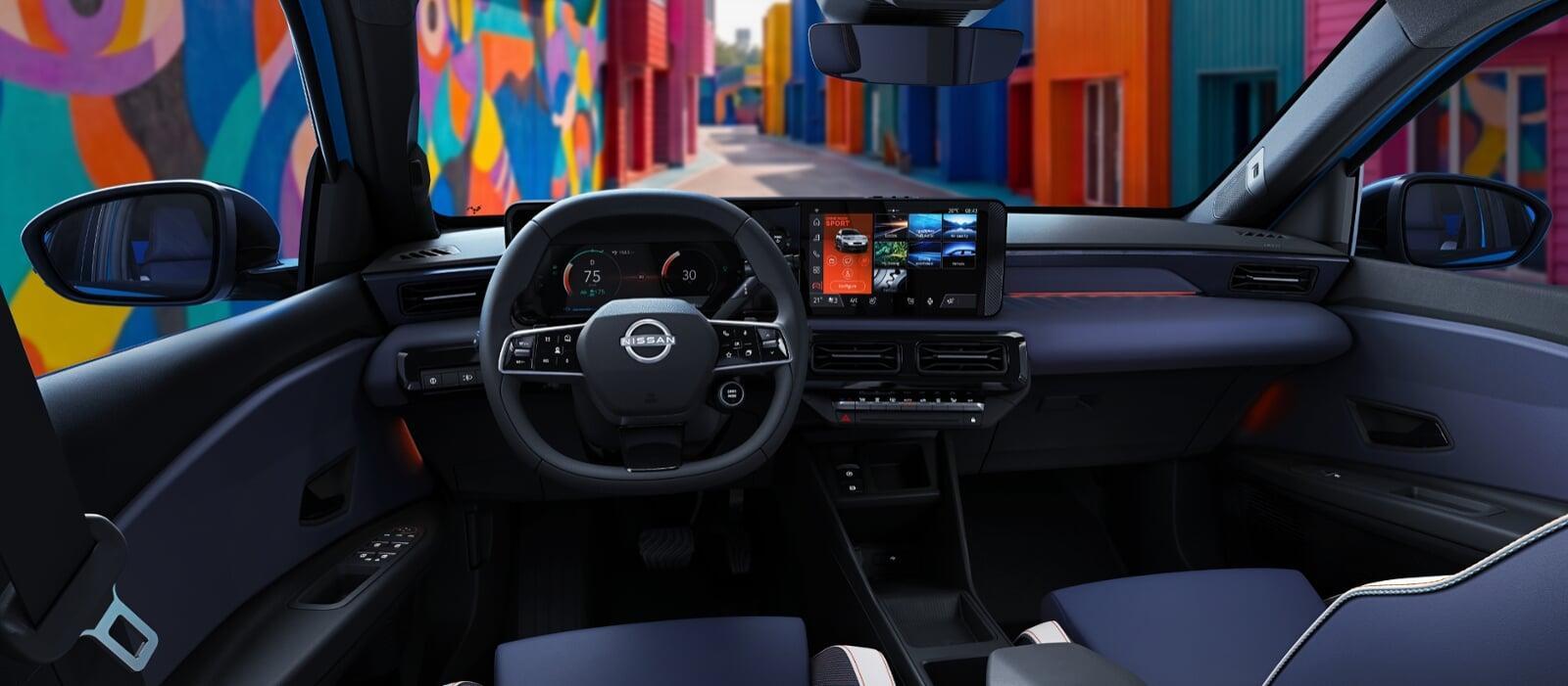 Interior do Nissan Micra elétrico mostrando painel digital, volante com logo Nissan e tela multimídia central, com mural colorido visível pelo para-brisa.