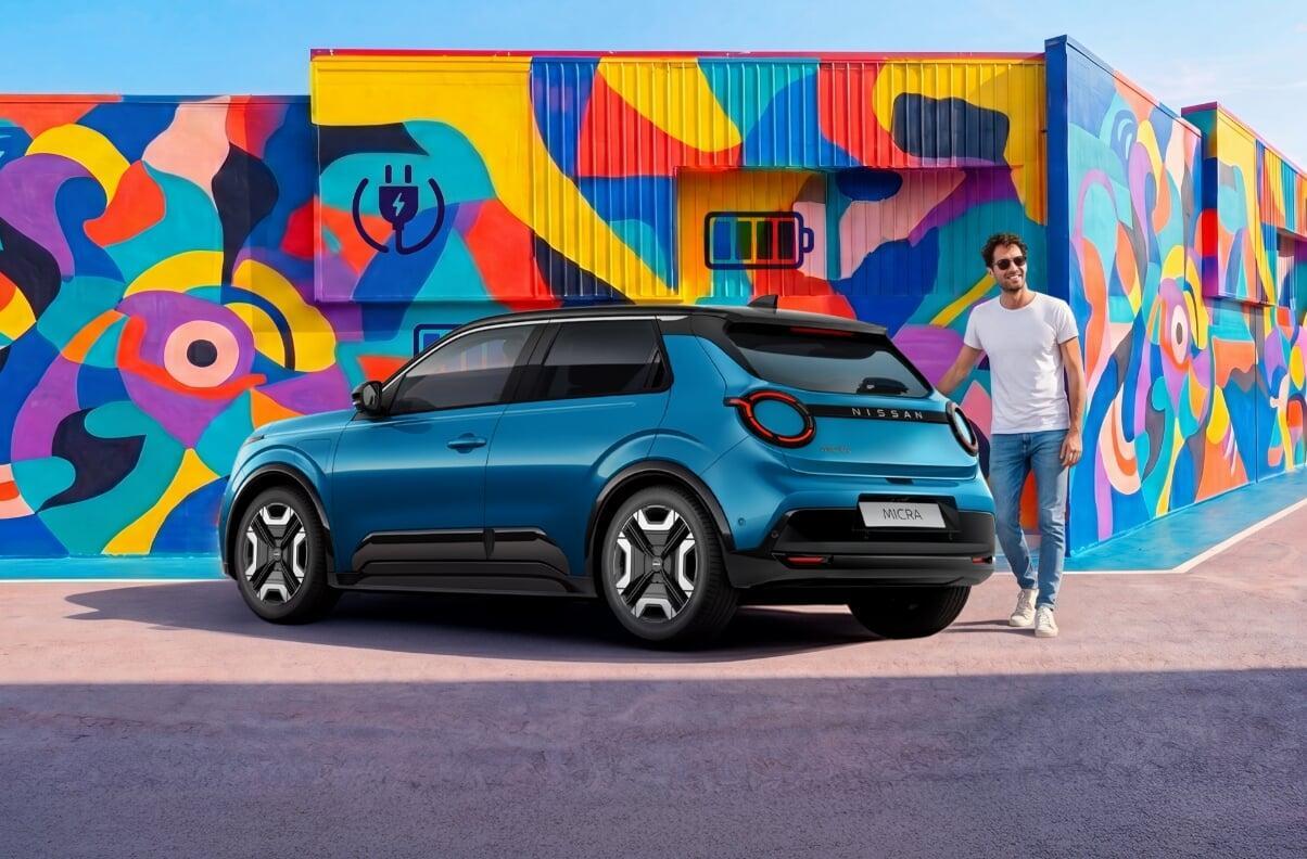 Nissan Micra elétrico azul visto de trás, estacionado diante de mural colorido com ícones de carregador e bateria; homem parado ao lado do carro.